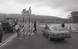 SUN-GAZETTE FILE PHOTO The barrier is removed, below, to allow the first car to cross the new Maynard Street bridge.